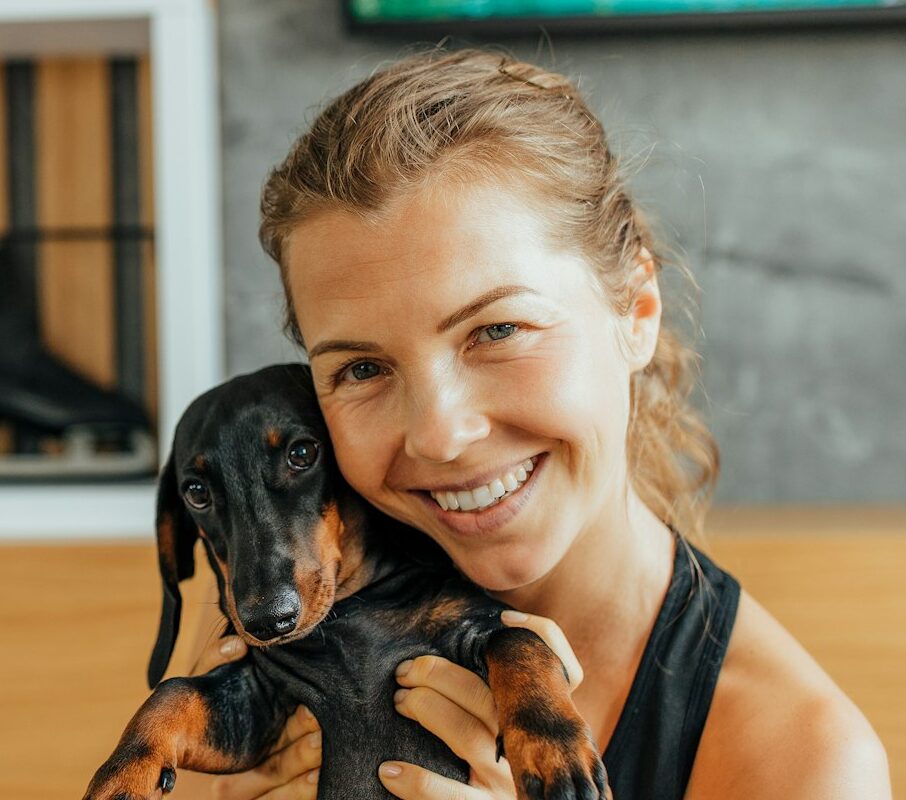Smiling face, woman holding her dog.
